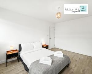 a bedroom with a bed and a table with towels at One Bedroom Apartment by Dream Key Properties Short Lets & Long Lets Uxbridge with Free Wi-fi - 5 in Uxbridge
