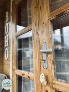 une porte en bois munie d'une poignée métallique dans l'établissement Little Wood Lodges Insolites, à Bailly-aux-Forges