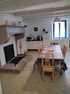 comedor con mesa y chimenea en Gîte des jardins, 