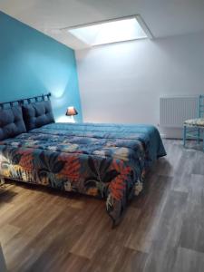 にあるGîte des jardinsの青い壁のベッドルーム1室(ベッド1台付)