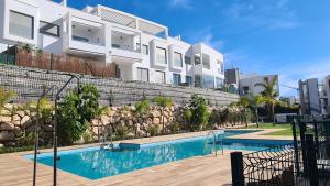 un edificio con piscina frente a un edificio en Piso Baviera Golf Costa del Sol en Caleta de Vélez