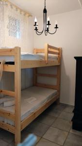 2 łóżka piętrowe w pokoju z żyrandolem w obiekcie Nikolas Villa w mieście Ambelas