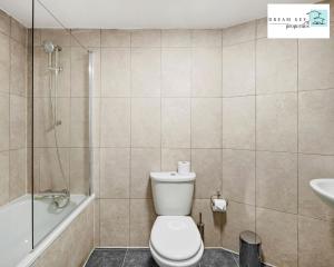 y baño con aseo, ducha y lavamanos. en Spacious Two Bedroom Apartment by Dream Key Properties Short Lets & Long Lets Uxbridge- 1, en Uxbridge