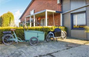 un vélo et un wagon garés devant une maison dans l'établissement Amazing Apartment In Otterndorf With Wifi, à Otterndorf