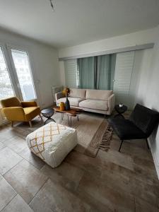 ein Wohnzimmer mit einem Sofa, einem Tisch und Stühlen in der Unterkunft Beau T3 60m2 très cosy proche du centre ville in Saint-Jacques