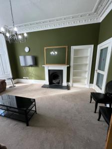 a living room with a fireplace and a tv at Sauchiehall Street West End Apartment in Glasgow