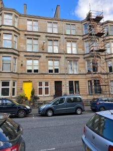 a building with cars parked in front of it at Sauchiehall Street West End Apartment in Glasgow