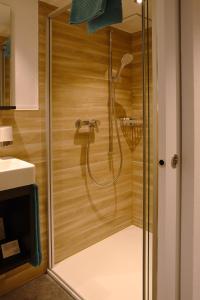y baño con ducha y puerta de cristal. en Landgasthaus Neues Bild, Eggerstanden, en Appenzell