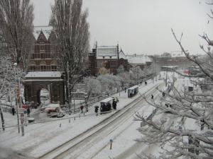 a train going down the tracks in the snow at Hotel Museumzicht in Amsterdam