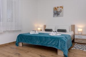 a bedroom with a bed with two towels on it at Blue Mile Apartman Split in Split