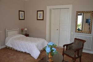 a bedroom with a bed and a chair and a mirror at Le stanze dei Mori - quadrupla con bagno privato in Mascalucia