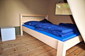 a wooden bunk bed with blue pillows on it at Safaritent Alkenhaer Appelscha in Appelscha
