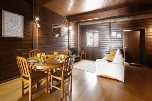 una sala da pranzo con un tavolo e un divano di Unique Wooden Cottage a Óbidos