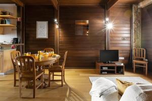 una sala da pranzo con tavolo, sedie e televisione di Unique Wooden Cottage a Óbidos