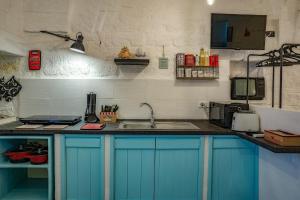 una cocina con armarios azules y fregadero en Casa Vacanze “House on the Left”, en Ceglie Messapica