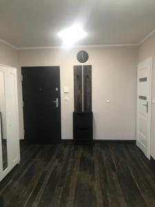 an empty room with a black door and wooden floors at Kawalerka na Targowej in Toruń