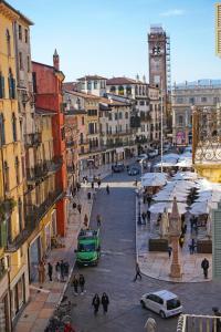 una calle de la ciudad con gente caminando y un autobús verde en Dimora Capuleti, en Verona