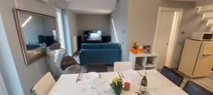 een kamer met 2 tafels en een woonkamer bij Il Profumo Dellegrazie in Le Grazie