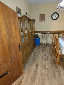 een kamer met een houten kast en een klok aan de muur bij Kuća za odmor i domjenke MARIS 