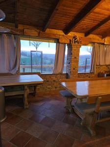een eetkamer met een tafel en ramen bij Kuća za odmor i domjenke MARIS 
