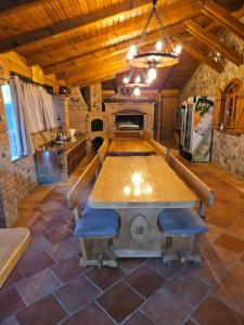 een grote houten tafel in een kamer met een open haard bij Kuća za odmor i domjenke MARIS 