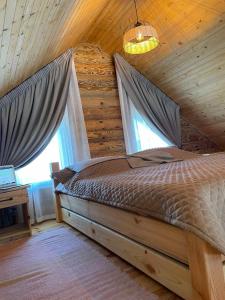 a bedroom with a bed in a log cabin at Затишний котедж в Білогородці in Belogorodka