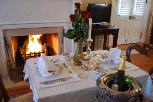 uma mesa com uma toalha de mesa branca e uma lareira em Hornsby House Inn em Yorktown