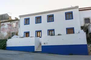 een wit en blauw huis met een hek bij Stylish Rustic Villa in Vau