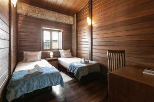 een kleine kamer met 2 bedden en een bureau bij Stylish Rustic Villa in Vau