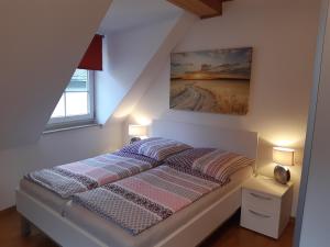 ein Schlafzimmer mit einem Bett mit einem Bild an der Wand in der Unterkunft Ferienhaus Würzgarten in Ürzig