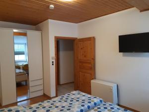 Schlafzimmer mit einem Bett und einem Flachbild-TV in der Unterkunft Ferienhaus Würzgarten in Ürzig