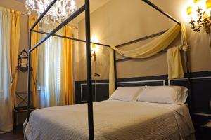 1 dormitorio con cama con dosel y lámpara de araña en Dimora Capuleti, en Verona