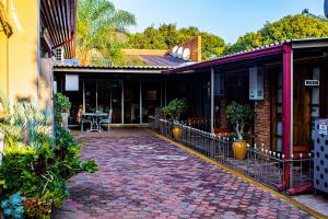 une passerelle en briques devant un bâtiment dans l'établissement Barlin Guesthouse, à Randfontein