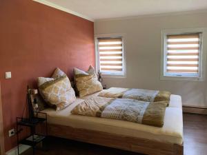 a bedroom with a bed with pillows on it at Wellness & Wirlpool-Oase am Wald - Waldferienhaus Dunja in Oybin in Hain