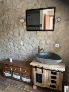 y baño con lavabo y espejo en una pared de piedra. en Waldferienhaus Dunja mit Whirlpool, Sauna u Garten, en Hain