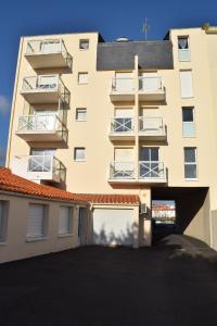 een appartementencomplex met een parkeerplaats ervoor bij Côte et Vie - appartement et garage in Saint-Gilles-Croix-de-Vie