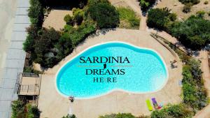 a swimming pool with a sign that reads sardinia dreams here at Villetta Flora with pool and private parking in Costa Paradiso