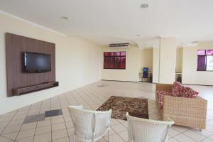 a living room with chairs and a flat screen tv at Litorânea Praia Hotel in São Luís