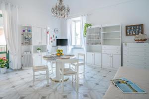 a white kitchen with a white table and chairs at Casa del Capitano in Vico Equense
