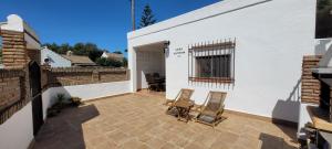 eine Terrasse mit 2 Stühlen und ein Gebäude in der Unterkunft Casa Antonia in Zahora