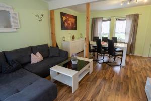 a living room with a couch and a table at Harznester - Ferienhaus am Thie in Blankenburg