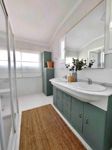 y baño con lavabo, espejo y ducha. en Caleta Beach House Villa Beatriz Sinese Design en Torre del Mar