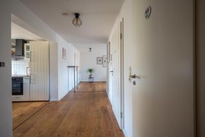 an empty hallway with a kitchen and an open door at Lotsenstation am Nord Ostsee Kanal in Schülp +9 photos