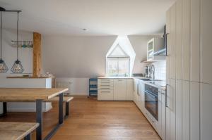 a kitchen with white cabinets and a wooden table at Lotsenstation am Nord Ostsee Kanal in Schülp