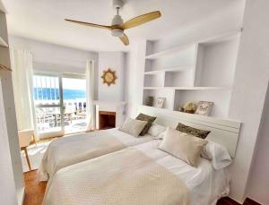 1 dormitorio con 2 camas y ventilador de techo en Caleta Beach House Villa Beatriz Sinese Design en Torre del Mar