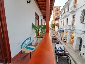 a balcony with a view of a street with chairs at Hotel Casa Agustina in Cartagena de Indias