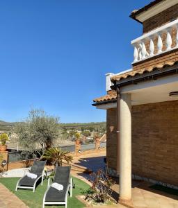 - un ensemble de chaises assises sur une terrasse dans l'établissement Villa Belephant Sitges, à Canyelles