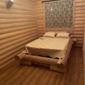 a bedroom with a bed in a log cabin at Yeghevni Rest House in Jermuk