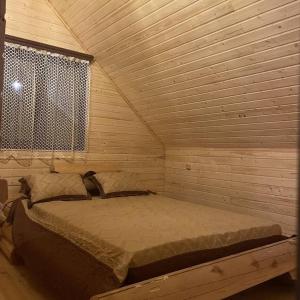 a bedroom with a bed in a wooden room at Yeghevni Rest House in Jermuk