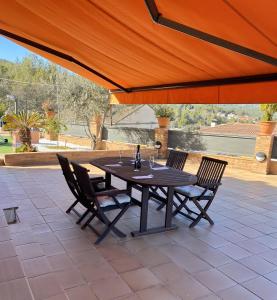 a black table and chairs under an orange umbrella at Villa Belephant Sitges in Canyelles